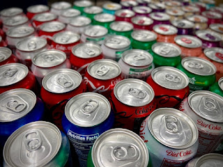 A large group of cans of soda photo by Charlie Wollborn on Unsplash - https://unsplash.com/photos/a-large-group-of-cans-of-soda-Yezt64WAT8A