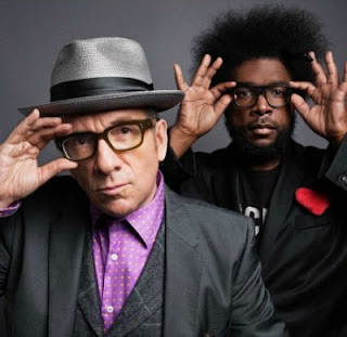 The Roots Walk Us Uptown Lyrics (ft. Elvis Costello)