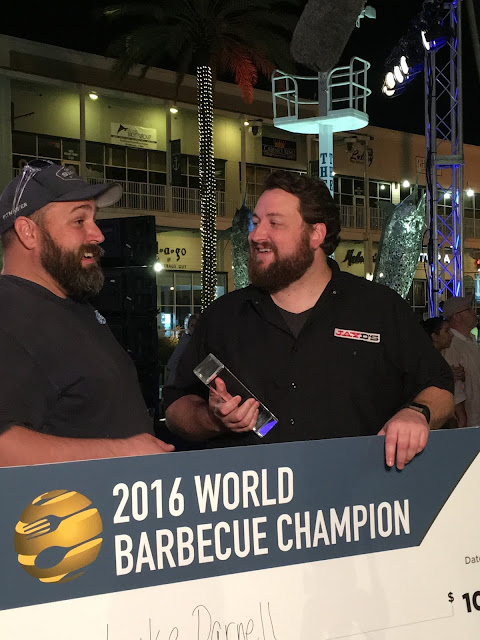 Luke Darnell and Jay Ducote celebrate Luke's $10,000 prize check an title of World Barbecue Champion!