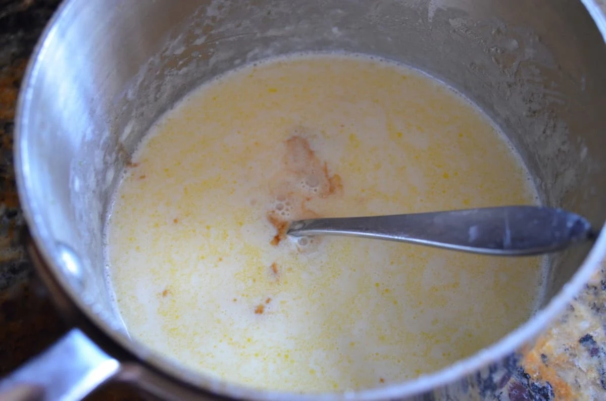 A small saucepan with melted butter, heavy cream and sugar.