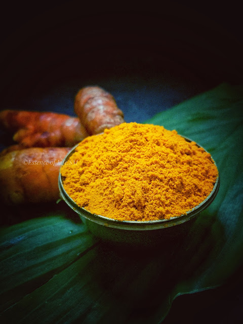 Freshly ground turmeric powder displayed with vibrant turmeric roots resting on a lush turmeric leaf, capturing the essence of pure, homemade spice creation.