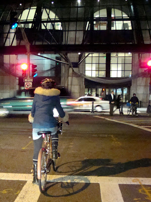 fur trimmed coat on a bike