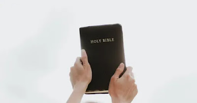 O persoană care ține cu ambele mâini de o biblie - foto de Priscilla du Preez - unsplash.com