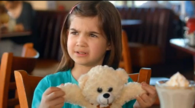 girl holding teddy bear's arms out and asking 'bear arms?'