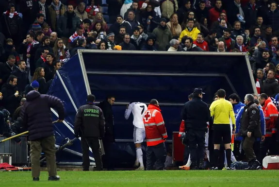 Cristiano Ronaldo grabs his head after being hit with a lighter upon leaving the field