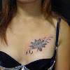 Tattoos On Breast Photos : Breast Cancer Tattoos That Have Changed Lives and Help ... : This tattoo, running between the wearer's breasts, depicts what looks like the side profile of three flowers.