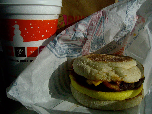 Dunkin' Donuts egg, cheese, sausage and breakfast sandwich with a coffee.