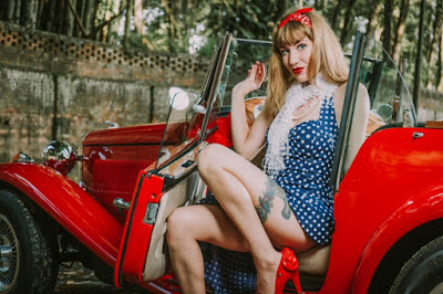 As linhas e a cor vermelha do carro combinam perfeitamente com a sensualidade da pinup.