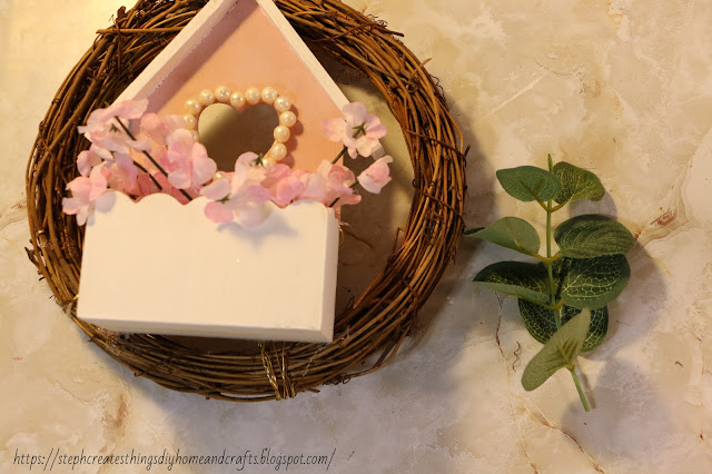 Faux floral inside of wooden heart box on wreath