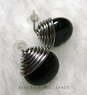 Holding a round Top Wrapped Stud Earrings