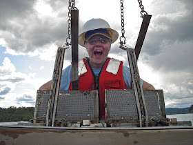 Female Ecology employee holds of a sample grab that came from Puget Sound. She is smiling because it was successful.