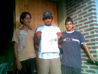 Cesar, Ignacio y Juan, en la puerta de la Capilla Nuestra Señora de Itatí, presentando el periódico que publicó la nota. Si desea contactarnos HAGA CLIC AQUÍ