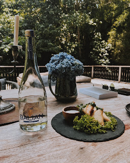 Mesa com flores, água e chamuças