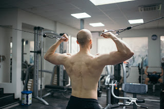 A person performing a drop set exercise with dumbbells, progressively lowering the weight as they fatigue.