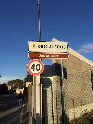 Sign for municipality (comune) of Orio al Serio at the edge of the airport. Underneath is the name of the municipality in the Bergamasco dialect: Öre al Sère).