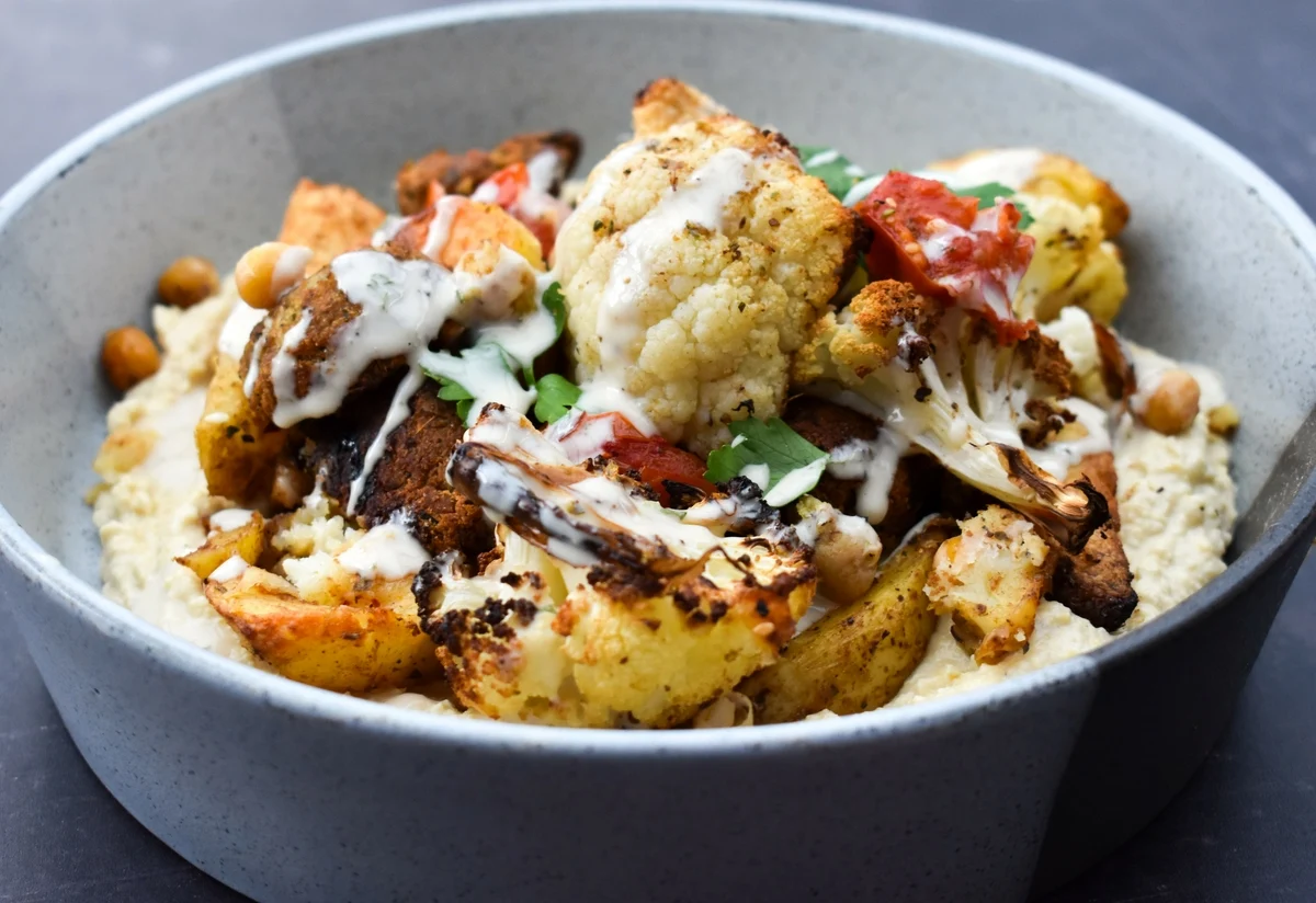 Lebanese roasted cauliflower bake topped with tahini dressing.