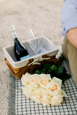 picnic basket with prosecco and white rose bouquet