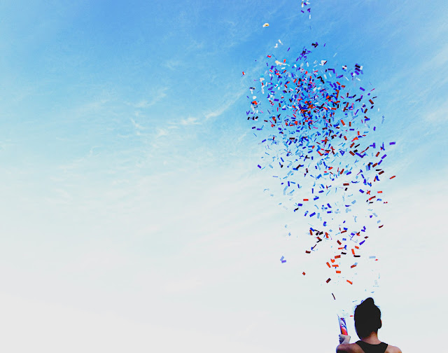 person firing small confetti cannon:Photo by Jason Dent on Unsplash