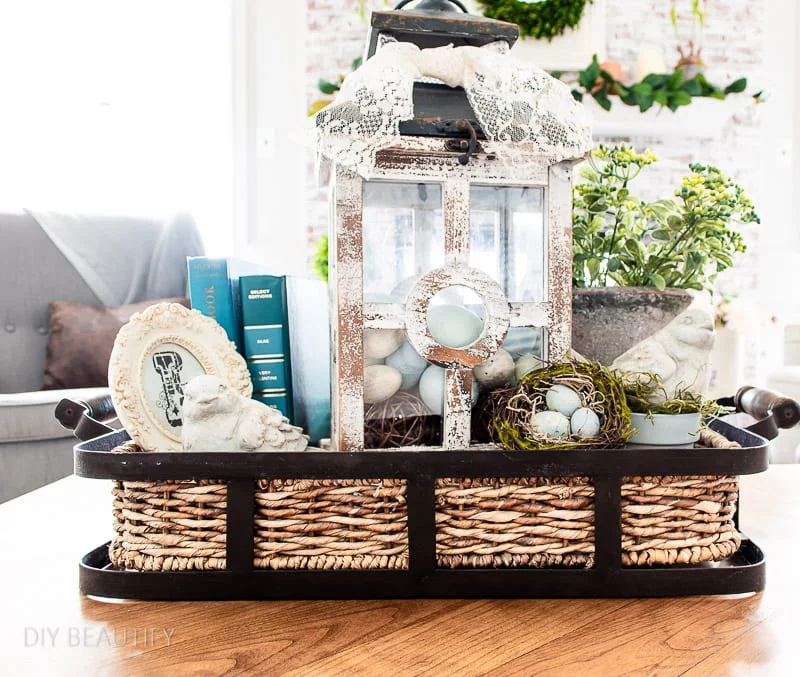 Spring tray with blue books, stone birds and lantern filled with eggs