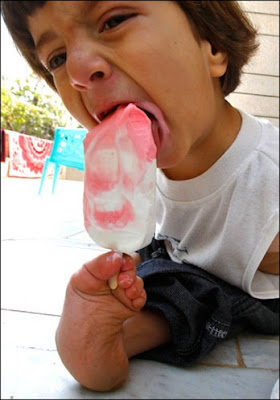 Ali licks his feet while eating ice cream at his parents' home in Amman