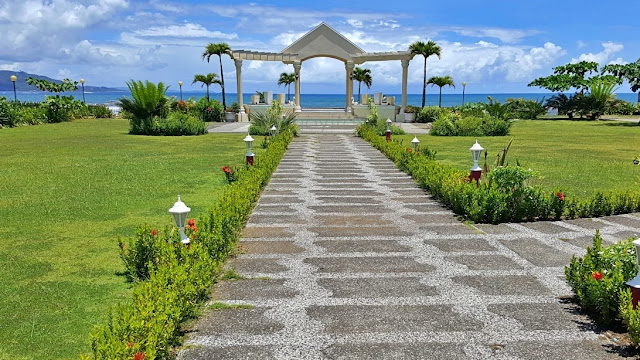 open garden with a view of the beach and the ocean at Villa Maria Luisa, Tandag City