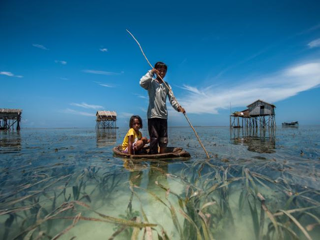 Foto de Ng Choo Kia - Crianças usam uma canoa tipica para pescar