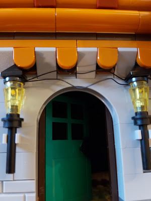 LEGO Alpine Lodge with lights to either side of the doorway