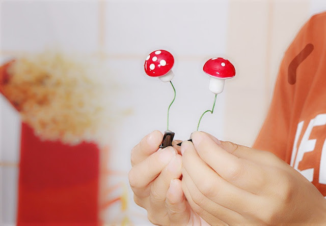 Hands holding up mushroom hair pins