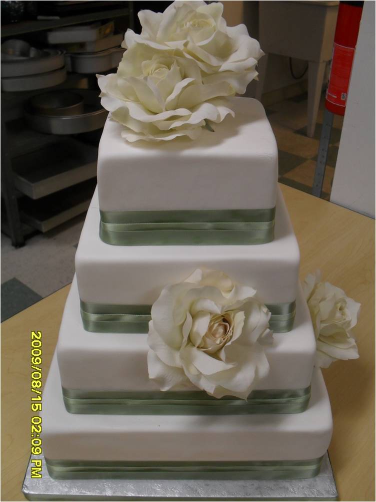 Pastel opaque green satin ribbon trimming on white wedding cake