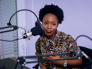 Woman podcasting in front of mic.