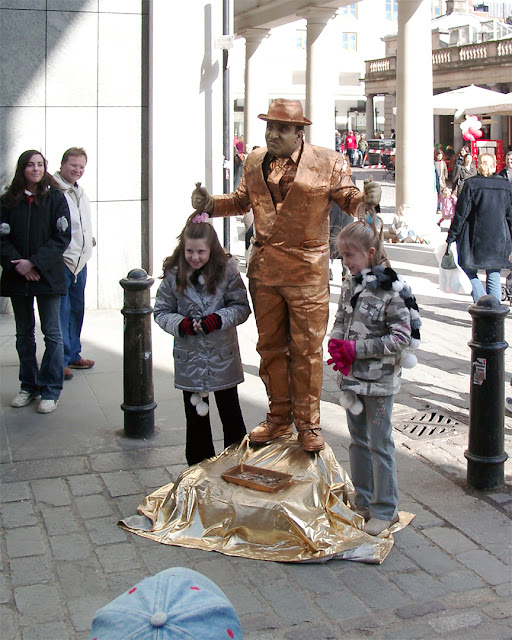 Girls posing with a street performer, Covent Garden, London