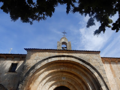 Parte alta de las arquivoltas de la ermita. Cruz en lo alto, copas de los árboles y cieloel aArquivoltas de laPar