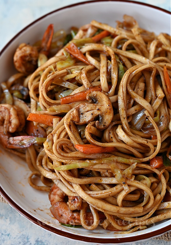 a close up of a plate with yaki udon with shrimp