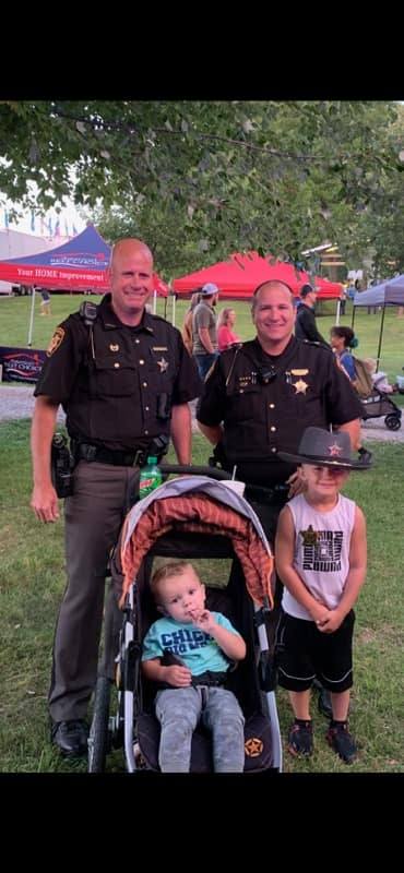 sheriffs with a family at sweet corn festival