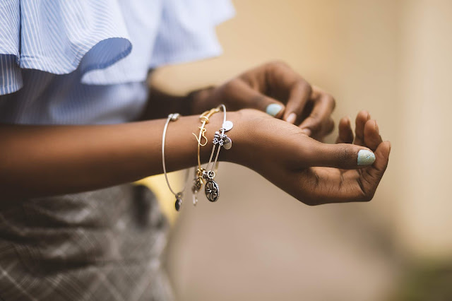 A close up shot of an arm wearing several bracelets.