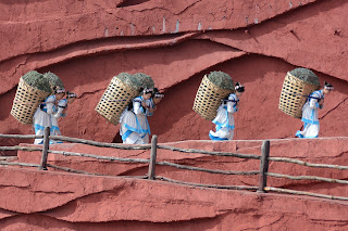 Women carrying baskets on their backs at the Impression Lijiang show