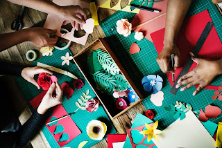 Made for community - several sets of hands working on colourful crafts together