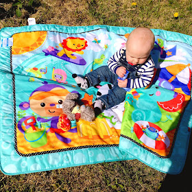 Jacob in the garden on his playmat in the sunshine 