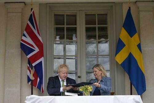 PA Wire: Boris Johnson and Swedish Prime Minister Magdalena Andersson exchange files as they sign a security assurance.