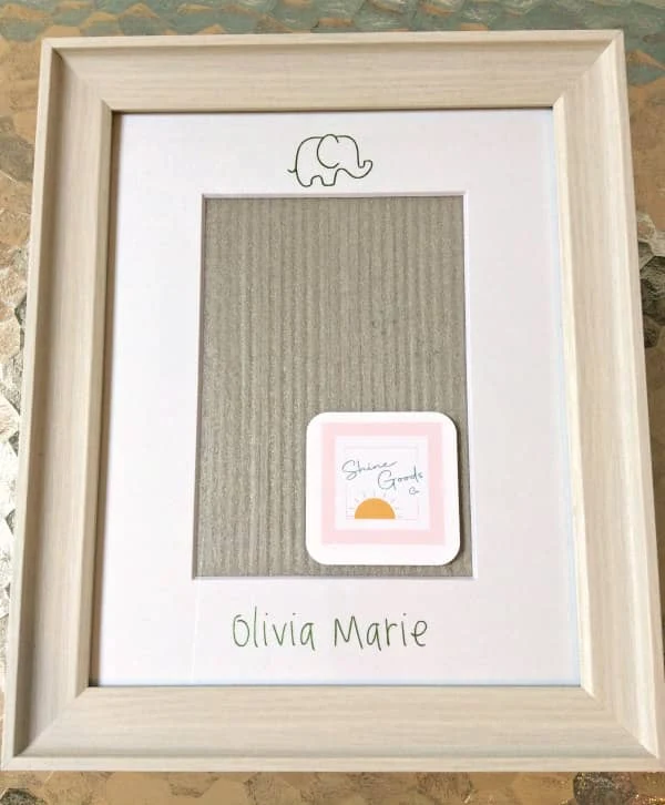 framed personalized foil transfer mat features baby elephant outline and baby's name in light green foil printing