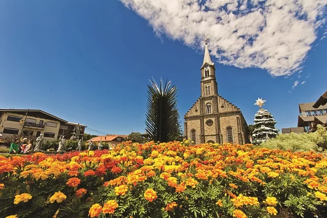 praça florida de gramado com igreja de pedra