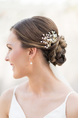 bride updo hairstyle braided bun with babies breath tucked in