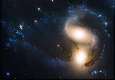  As galáxias ejetam matéria em volume muito maior do que se calculava.(Imagem: Hubble/NASA/ESA/Jose Jimenez Priego)  Poeira de galáxias  Sabendo que todos os átomos mais pesados - do hélio para cima na tabela periódica - são criados nas estrelas, costuma-se dizer que todos nós somos seres feitos de "poeira de estrelas".  Mas parece que nossos elementos constituintes - e de tudo o mais que conhecemos, inclusive da Terra - não vieram apenas de vizinhanças mais próximas.  Na verdade, parece que pelo menos metade dos nossos corpos são "poeira de galáxias" - de outras galáxias, que não a nossa aconchegante Via Láctea.  "Nós não nos damos conta de quanto da massa das atuais galáxias similares à Via Láctea foi na verdade 'roubada' dos ventos de outras galáxias," disse Claude Faucher Giguère, da Universidade Northwestern, nos EUA.  Até agora os astrofísicos calculavam que as explosões estelares - as novas e supernovas - não teriam força suficiente para arremessar poeira pelos gigantescos espaços intergalácticos, mas Giguère e seus colegas demonstraram que não é bem assim.  Transferência de massa entre galáxias  Usando modelos 3D da evolução das galáxias, a equipe simulou o caminho que a matéria ejetada das explosões estelares teria seguido desde o Big Bang até hoje. As simulações mais precisas das supernovas revelaram que os ventos galácticos empurram a matéria muito mais rapidamente do que se pensava anteriormente, permitindo que elas atinjam outras galáxias.  Os cálculos indicam que, no tempo de vida de uma galáxia, ela troca matéria continuamente com suas vizinhas, com a jornada entre uma galáxia e outra desses átomos, moléculas e até compostos moleculares, levando de algumas centenas de milhões de anos até 2 bilhões de anos, contou Giguère.  Em galáxias com 100 bilhões de estrelas ou mais, os ventos galácticos podem ter transportado cerca de 50% da matéria atual dessas galáxias - dela para outras, e de outras para ela. Esse percentual é menor para as galáxias menores.  Se as simulações estiverem corretas, galáxias grandes como a nossa podem ter na matéria intergaláctica o principal elemento que as permitiu crescer - até metade de toda a sua massa pode ter chegado pelos ventos intergalácticos.  Cosmologia extragaláctica  Outros pesquisadores que checaram os cálculos gostaram da análise, como a professora Jessica Werk, da Universidade de Washington, que afirma que rastrear o fluxo da matéria da origem do Universo até o presente, e entender onde surgiram os átomos que compõem o ar que respiramos e a água que bebemos, é um dos problemas fundamentais da astrofísica.  "É um dos cálices sagrados da cosmologia extragaláctica. Agora, descobrimos que a metade desses átomos vem de fora da nossa galáxia," concluiu ela.  Fonte: New Scientist  Bibliografia:  The cosmic baryon cycle and galaxy mass assembly in the FIRE simulations Daniel Anglés-Alcázar, Claude-André Faucher-Giguère, Dusan Keres, Philip F. Hopkins, Eliot Quataert, Norman Murray Monthly Notices of the Royal Astronomical Society DOI: 10.1093/mnras/stx1517