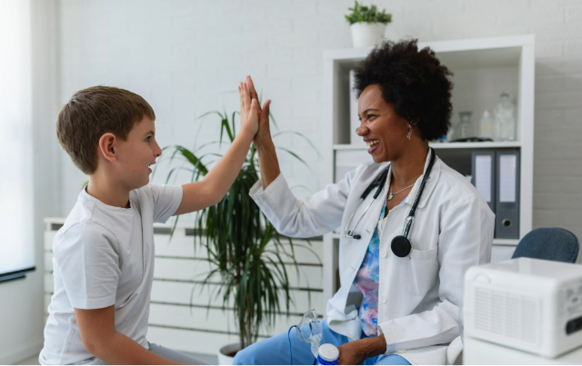 Doctor high fiving a young patient.