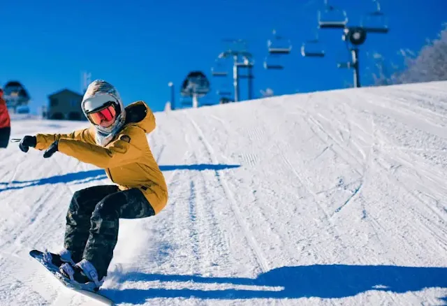 A man with yellow jacket ski on snow