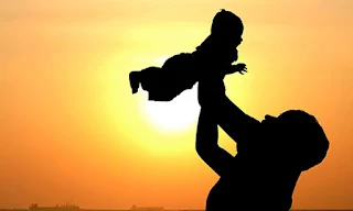 Silhouette of a woman throwing a baby into the air.