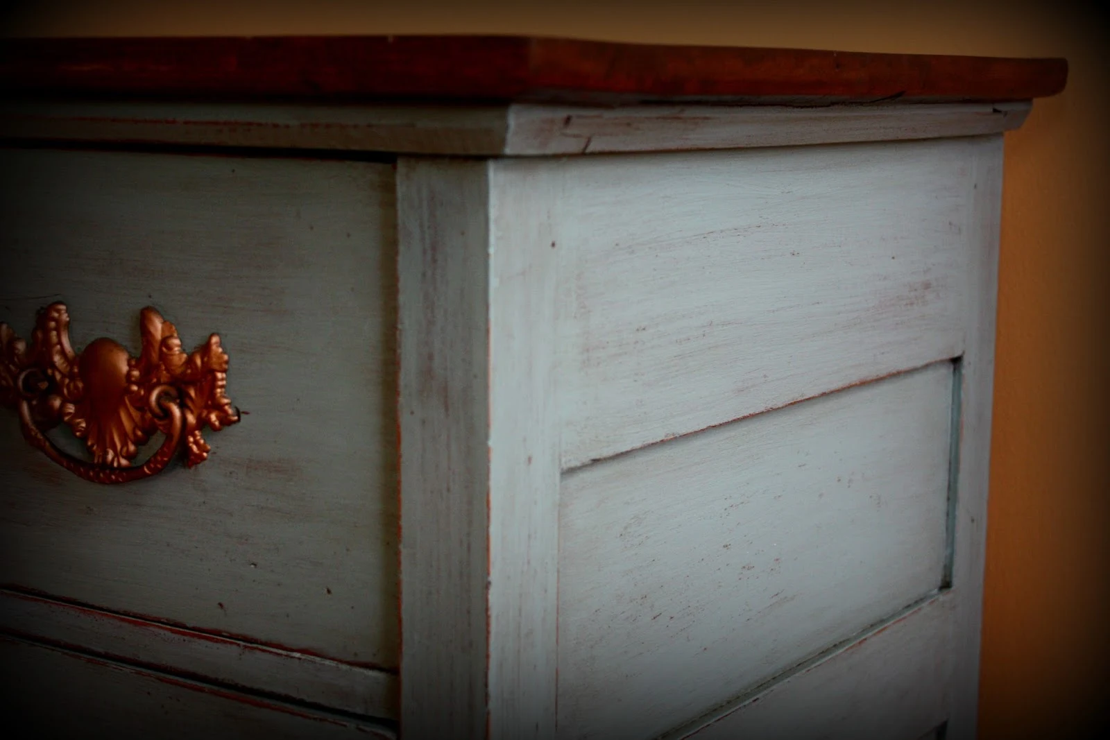 Stained top, blue base, and copper drawer pulls.