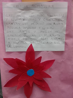 Una foto con un poema escrito en lápiz con una flor debajo hecha por los niños 