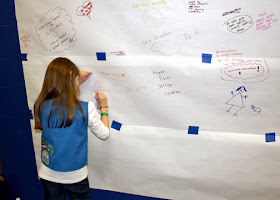 Tessa drew a picture of her at a cookie booth on the community share-a-cookie-selling-tip wall at Cookie Rally 2014.