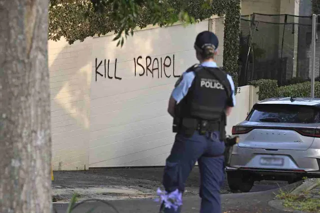 A police officer stands near anti-Israel graffiti painted on a wall in Sydney, Australia, on December 11, 2024. Photo by Mick Tsikas/AAP Image